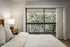 Carpeted bedroom with queen bed, rustic furniture and sliding glass door overlooking balcony.