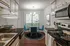 Kitchen with black granite countertop, white classic cabinets, and stainless steel over overlooking dining area with full size window