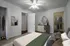 Bedroom with low queen bed and open closet. Clothes are hanging in the closet.