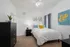 Bedroom with ceiling fan, window, furniture.