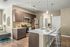 Kitchen area with wood tiled floors, stainless steel appliances, dark cabinets, modern lighting.