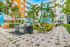 Beautifully landscaped courtyard with plenty of lounge chairs, Italian garden style, string lights.