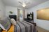 Bedroom with ceiling fan, window, furniture.