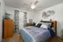 Bedroom with ceiling fan, window, furniture.