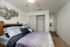 Bedroom with ceiling fan, window, furniture.