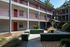 Community exterior with 3 floors, path and small palm trees