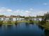 Pond with retaining wall, buildings and trees in the background.