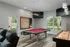 Community game and movie room with pool table, shuffleboard, leather recliners and large TV.