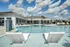 Pool with waterfall and lounge chairs, clubhouse in background
