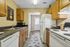 Galley kitchen with cabinets and appliances on each side.