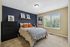 Bedroom with bed, dresser, and desk.