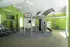 Spacious gym with modern exercise equipment and vibrant green walls.