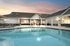 Inviting outdoor pool area with modern sun loungers and sleek patio umbrellas, perfect for socializing and relaxation.