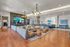 Luxurious living area with plush sectional sofa, vibrant decor, and sleek hardwood flooring, featuring modern lighting and a spacious, inviting ambiance.
