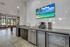 Modern communal area with sleek stainless steel appliances, vibrant wall art, and ample natural light through large windows for a welcoming atmosphere.