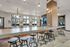Inviting communal space with modern bar seating, stylish pendant lights, and a cozy seating area enhanced by large windows.