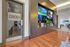 Luxurious apartment lounge featuring a private cinema room entrance, vibrant wall display, and elegant hardwood flooring.