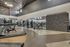 Modern fitness center with state-of-the-art gym equipment, climbing wall, and spacious mirrored walls, offering an energizing workout experience.