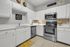 Charming modern kitchen with sleek white cabinets, stainless steel appliances, and decorative accents.