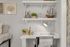 Cozy and stylish study nook with decorative shelves, featuring a model ship, elegant vases, and a modern desk lamp complementing a chic workspace.