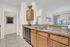 Bright and inviting kitchen with modern appliances, sleek countertops, and ample cabinetry opens to a warmly lit living area.