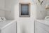 Charming laundry room with modern washer, dryer, and welcoming chalkboard message.