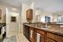 Inviting kitchen with polished granite countertops, dual sinks, modern appliances, and a cozy welcome home sign.