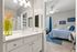 Inviting bathroom with modern vanity and vibrant decor, leading to a cozy bedroom with nautical-themed accents and soft natural light.