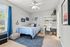 Bright and airy bedroom with nautical decor, featuring a cozy bed, modern workspace, and stylish accents in a serene setting.