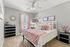 Charming bedroom with modern decor, featuring a cozy bed adorned with blush pink accents, decorative pillows, and elegant wall art, creating a serene retreat.