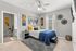 Bright and cozy bedroom featuring modern decor, elegant wall art, and a comfortable bed with vibrant cushions.