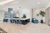 Modern communal space with sleek bar seating, stylish pendant lighting, and a cozy seating area with lush greenery.