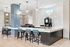 Chic coffee bar area with modern seating, stylish pendant lighting, and a sleek espresso machine.