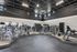Modern gym interior featuring a variety of cardio machines and a mirrored wall in a sleek, spacious environment.