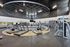 Modern gym facility with state-of-the-art exercise equipment, including treadmills, stationary bikes, and weight machines, within a sleek, open design.