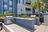 Inviting outdoor barbecue area with modern grills and a landscaped backdrop in a vibrant apartment community.