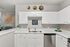 Modern kitchen with elegant white cabinetry, sleek countertops, stainless steel dishwasher, and charming decorative elements, perfect for culinary creativity.