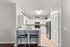 Contemporary kitchen boasting sleek white cabinetry, modern appliances, and a cozy breakfast bar with stylish seating.
