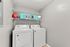 Chic laundry room boasting a modern washer and dryer set with elegant shelving and decor. Perfect blend of functionality and style.