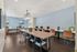 Modern and inviting coworking space featuring elegant wooden table, stylish chairs, and chic lighting accents, ideal for productivity.
