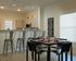 The Station at Alafaya, interior, dining room kitchen, black table for four. large window, breakfast bar seating for four, tan cabinets, stainless steel microwave