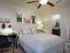 The Station at Alafaya, interior, bedroom, carpet, green and gray bed, black desk and chair, ceiling fan, bathroom doorway