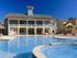 The Station at Alafaya, exterior, two level clubhouse with balcony, sparkling blue swimming pool, yellow house