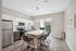 Modern kitchen with sleek stainless steel appliances, chic white cabinetry, and a stylish island with comfortable seating and natural light.