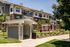 Charming apartment exterior with a modern mailbox structure and inviting outdoor seating area surrounded by lush greenery.