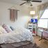 Cozy bedroom featuring plush bedding, stylish decor, and a bright study nook with natural light.