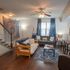 Inviting living room with elegant hardwood floors, cozy seating, and vibrant decor, complemented by abundant natural light.