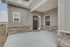 Charming modern home entrance featuring a welcoming stone facade, stylish black door, and elegant bay windows.