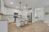 Bright and modern kitchen with sleek stainless steel appliances, elegant pendant lighting, and a cozy breakfast bar.