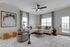 Elegant living room featuring a cozy sectional sofa, modern artwork, and abundant natural light through large windows.